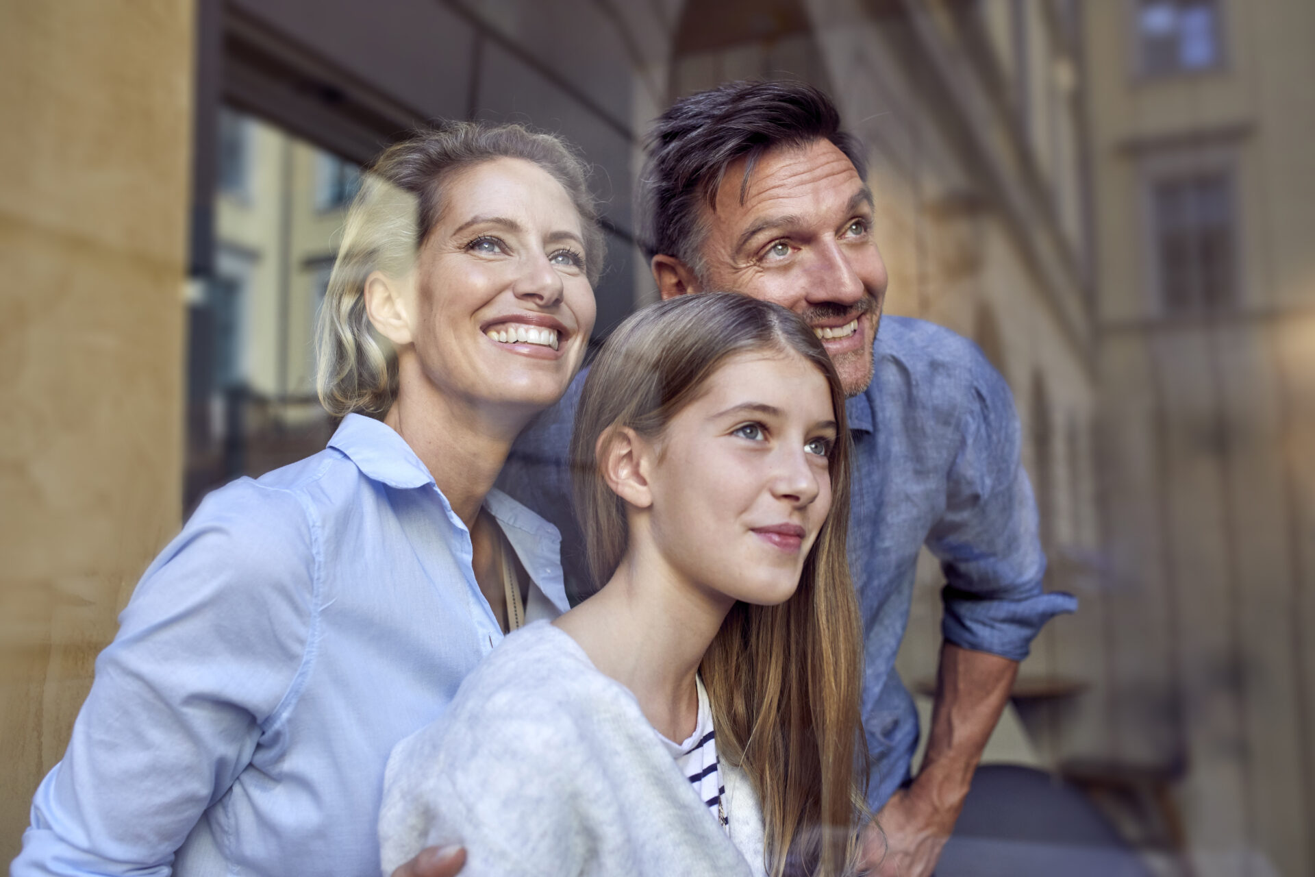Portrait of happy family behind windowpane